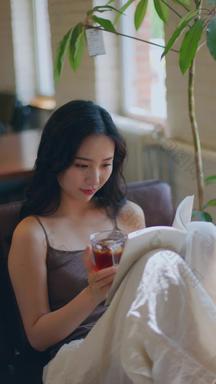 年轻女人在家喝茶看书